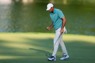Scottie Scheffler punches the air after his birdie putt on 17